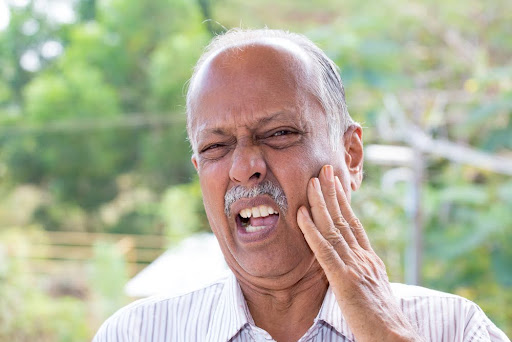 man experiencing oral pain from infected tooth