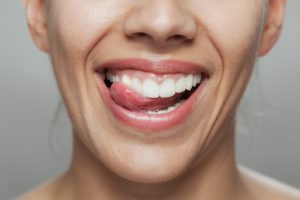 close up of tongue poking between teeth