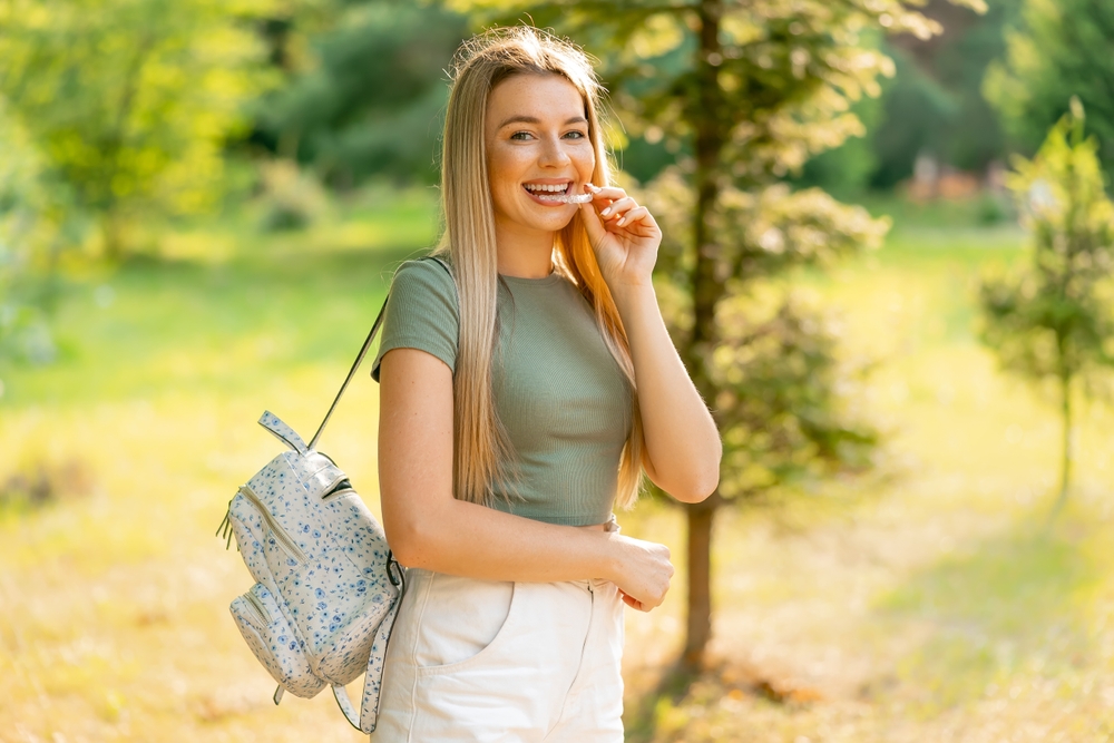 busy blonde woman outdoors with invisalign